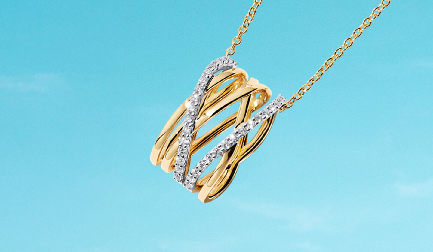 A yellow gold and diamond Ros&eacute;e du Matin necklace on a blue background.